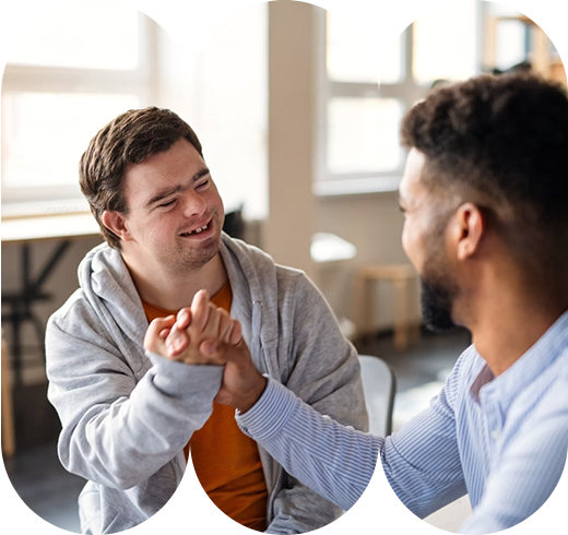 Image of an NDIS participant and support worker sharing a moment of connection with a friendly handshake